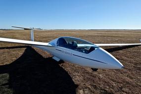 Shiny glider on the colorful field in sunlight, under the blue sky