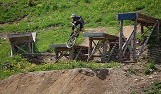 Person in helmet, jumping from the hill with obstacles
