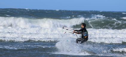 the athlete rides the waves on kitesurfing