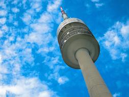 Low angle shot of the Olympia Tower in Munich, Germany, under the blue sky with white cloud