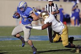 fighting for the ball in American football on the field during the game