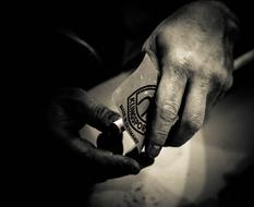 Black and white photo with close-up of the hands of the person playing pool