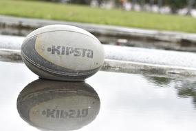 rugby ball kipsta in a puddle