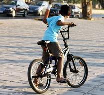 little boy riding his bike down the street