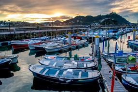 Colorful boats in the beautiful port of Spain, near the mountains, at colorful and beautiful sunset