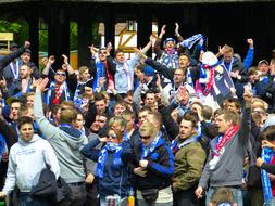 Fans celebrating football, in sunlight