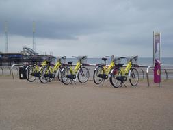 Bike hire on the sandy beach near the water, under the clouds