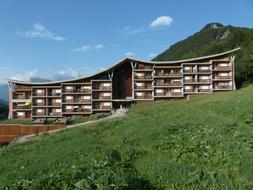 Colorful Hotel on the mountains in Limonetto, Italy, under the blue sky with clouds