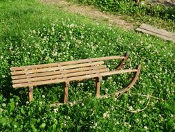 wooden sleigh on green grass on a sunny day