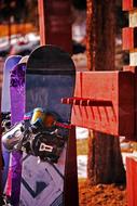 a snowboard stands near a wooden fence