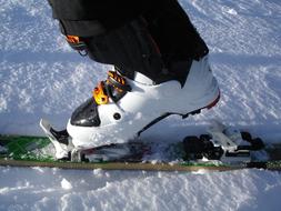 Close-up of the skier's leg in the ski, above the snow in light