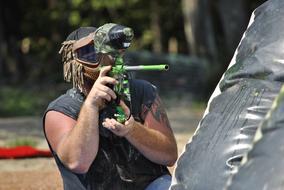 sportswoman shoots paintball on blurred background