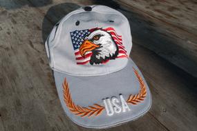 Colorful baseball cap with flag and eagle and "USA" sign, on the wooden surface