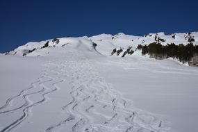 Beautiful landscape of the snowy mountains with backcountry skiing traces, under the blue sky