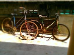 a pair of old bicycles near the building on the street