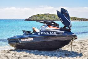Colorful rescue jet ski on the sandy beach in sunlight