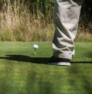 man stands near the ball on the golf course