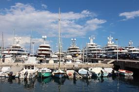 Colorful ships in the port of Monaco, under the blue sky with clouds