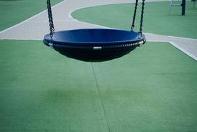 Close-up of the blue, hanging toboggan, above the green surface