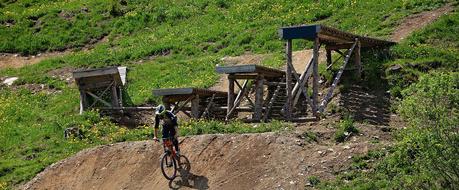 a man on a bicycle jumping over a hill