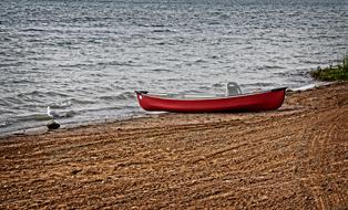 red canoe on the sandy shore