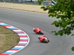 Andrea Dovizioso and Nicki Hayden, riding on the bikes on the road, on the competition