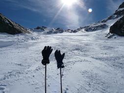 gloves on sticks on a background of snowy mountains