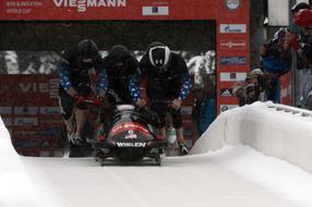 Bobsled team in colorful equipment, on the competition