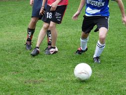 feet of young players and a soccer ball