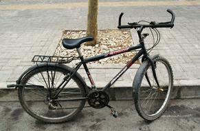 old bike parked on the city sidewalk