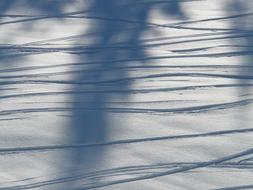 Close-up of the traces on the beautiful, shiny snow in sunlight and shadows, in the winter