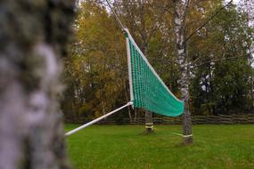 Volleyball Net attaches to trees in garden at autumn
