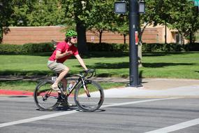 cyclist in green helmet at city crossroads