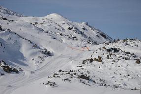 Beautiful, snowy mountain with the ski traces, in sunlight, at blue sky on background, in Austria