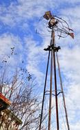 windmill on a metal structure in a village