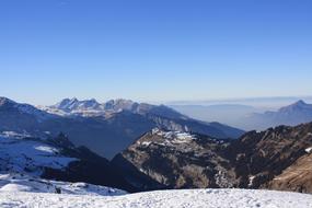 Beautiful landscape of the snowy mountains in sunlight, in clouds, under the blue sky