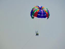 athletes fly on a colorful parachute