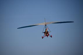 Flying motor glider in light, under the blue sky