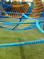 Close-up of the blue and yellow sport network, with shadows above the green grass