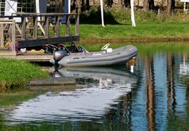 gray dinghy on the water near the shore