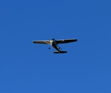 Low angle shot of the flying aircraft, under the blue sky