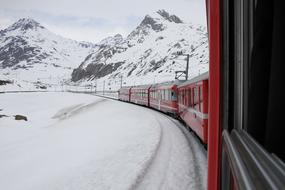 red train on Bernina Railway at winter, switzerland