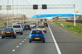 Colorful cars on the road, with the blue and white aircraft, in Amsterdam, Netherlands