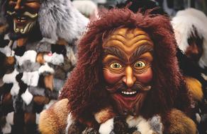 person in Human carnival mask and fur coat