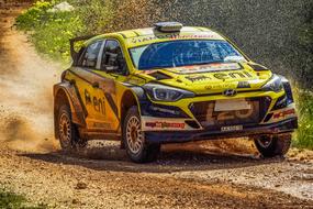 yellow car on a dusty race track