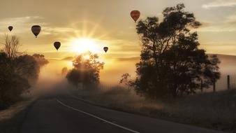 hot air balloons fly against the evening sky