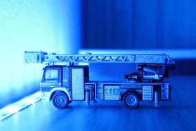 Side view of the fire truck, with the turntable ladder, in blue colors