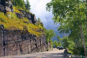 road near rock in scenic landscape, usa, montana, glacier national park