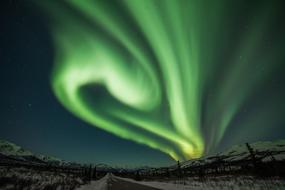 northern lights over the road at night