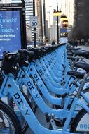 blue bicycles parked on the street for rent